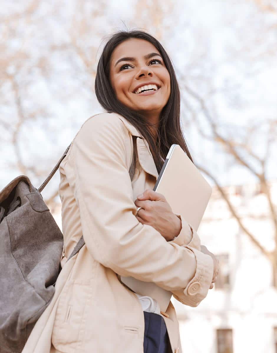 Businesswoman holding laptop and smiling