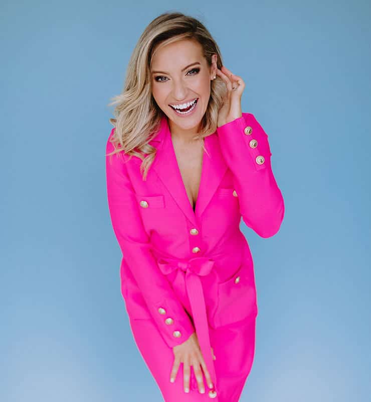 Emily Osmond, an SEO Strategy client of Rachel Jane Design, wearing a pink dress and laughing.